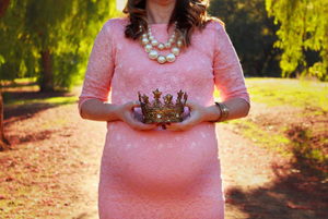 Pregnant woman holding a crown